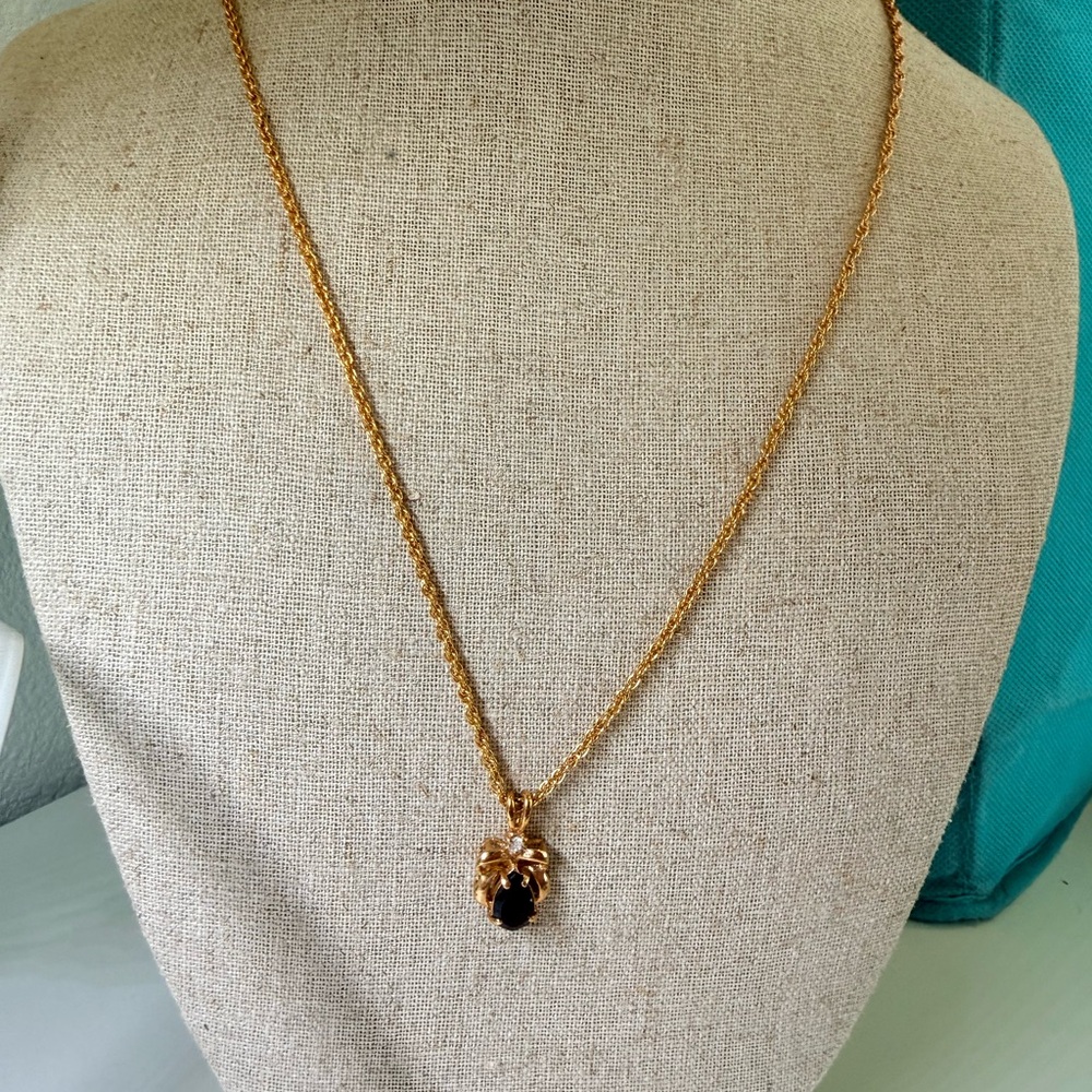 Gold tone necklace with deep red pendant